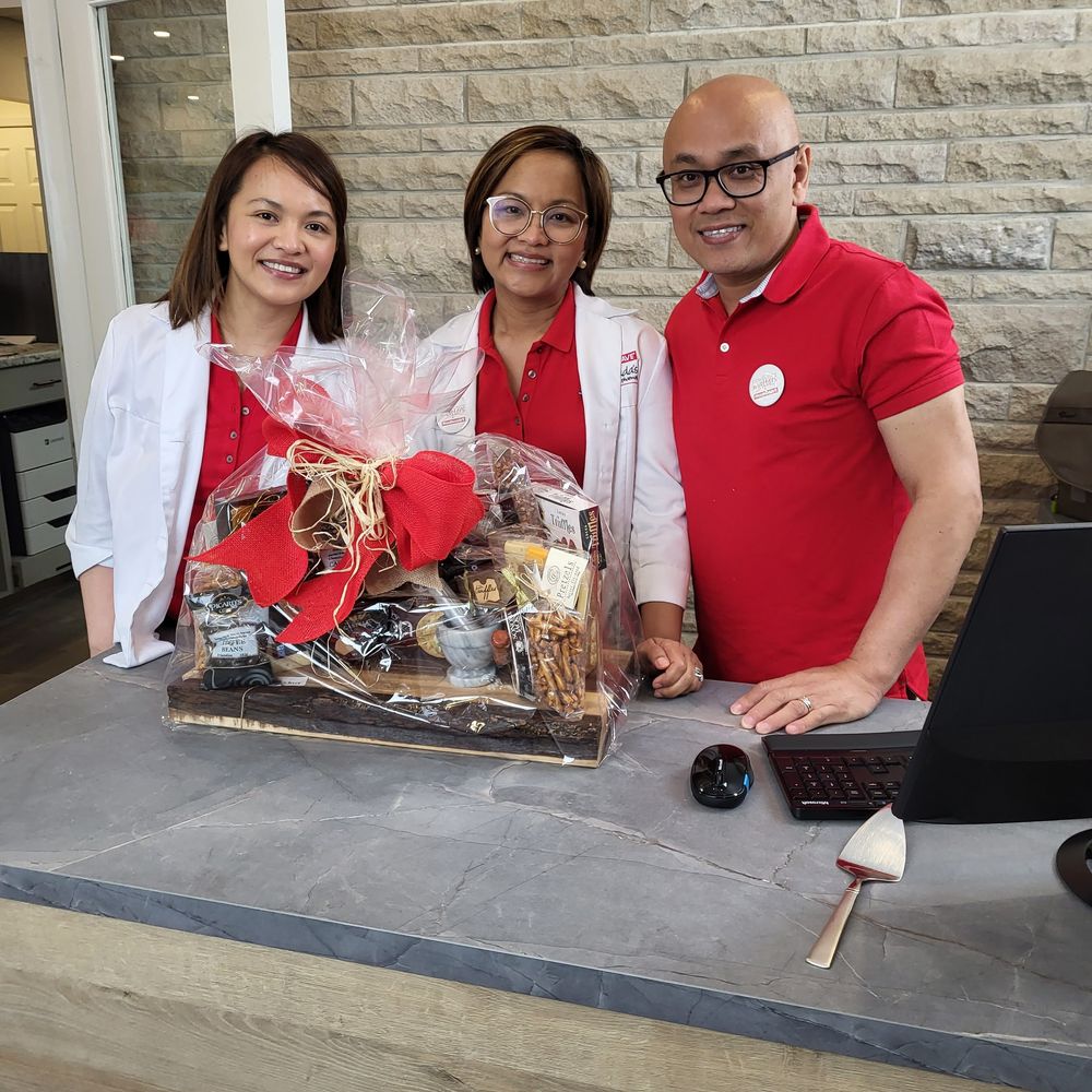 Happy customers holding a Baskets Ahoy gift basket at their store counter.